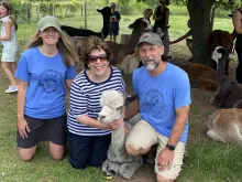 Owners Aron and Kari with a guest and alpaca Chloe