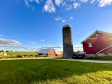 people dining in a farm landscape with barns on a sunny summer day