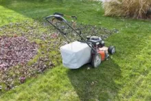 Push lawn mower with leaf bag attached.