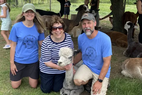 Owners Aron and Kari with a guest and alpaca Chloe